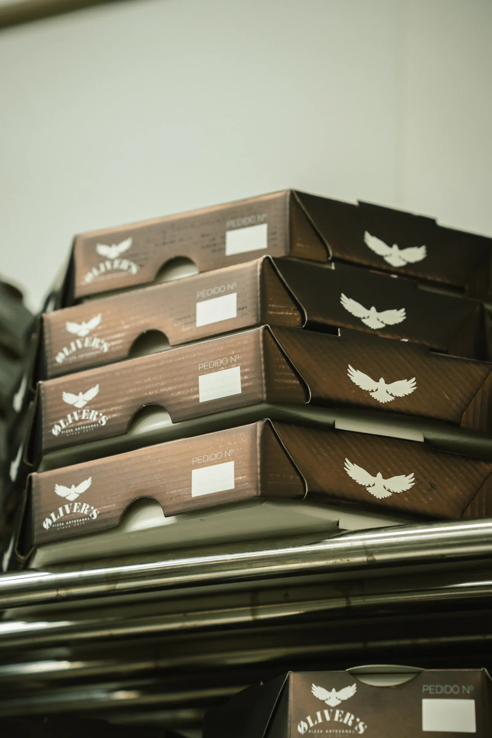 Caixas da Øliver's Pizza empilhadas prontas para o delivery