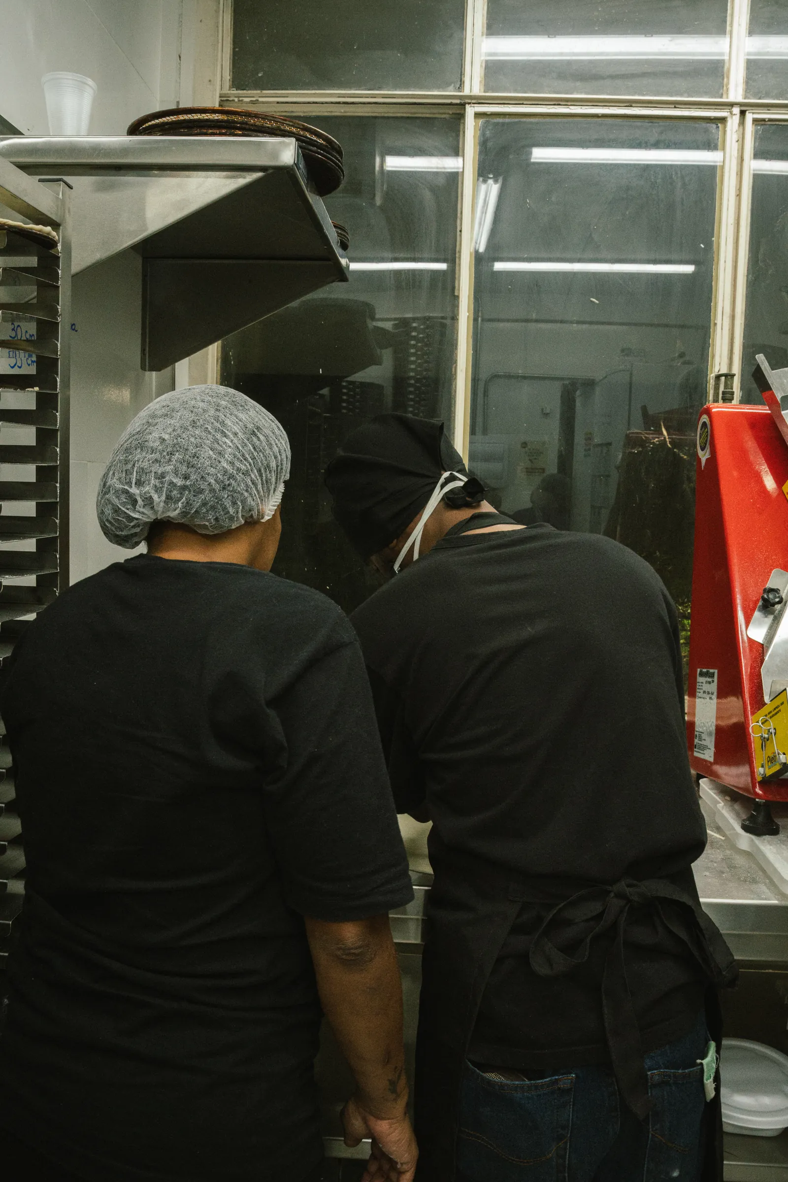 Dupla da cozinha operando a bancada durante o turno